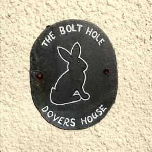 a black button with a rabbit that says the buthowers house at The Bolt Hole - Looe. in Looe