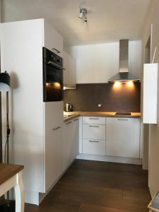 een keuken met witte kasten en een koelkast bij Location Studio avec Jardin en Hameau II in Gréolières
