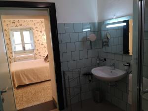 a bathroom with a sink and a room with a bed at Casa Pagiò in Bosa +46 photos