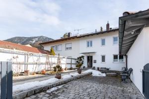a white house with a courtyard with potted plants at Panoramahaus Hopfner Nähe Zugspitze und Eibsee in Garmisch-Partenkirchen