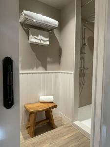 a bathroom with a shower and a stool with towels at L' Alzina in Falset
