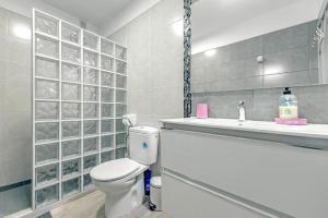 łazienka z toaletą i umywalką w obiekcie Neptuno Oceanview Suite with pool and beach private access w mieście Puerto de Santiago