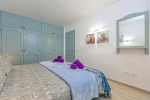 sypialnia z łóżkiem z fioletowymi misiami w obiekcie Neptuno Oceanview Suite with pool and beach private access w mieście Puerto de Santiago +10 zdjęć