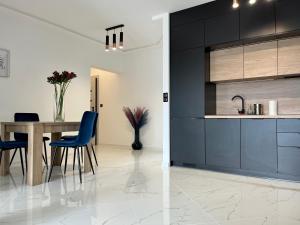 une cuisine et une salle à manger avec une table et des chaises bleues dans l'établissement Apartament Charlotte Link, à Jelenia Góra