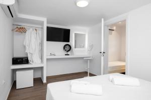 a white room with a bed and a desk at Kasteli Suites in Perivolos
