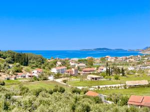 a small village with the ocean in the background at Luxury Villa Makris with private heatable pool in Kavvadádes