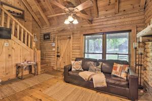 a living room with a leather couch in a log cabin at Secluded Cabin with Fishing Pond near Hunting! in Bessemer