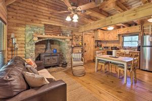 a living room with a couch and a fireplace at Secluded Cabin with Fishing Pond near Hunting! in Bessemer