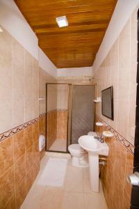 a bathroom with a toilet and a shower and a sink at Hotel Ancor in Sincelejo