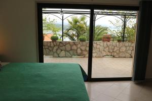 a bedroom with a sliding glass door to a patio at Apartments Komel II in Opatija