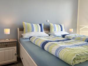 dos camas sentadas una al lado de la otra en un dormitorio en ZUM LEUCHTTURM Wellness-Appartement APPARTO Grömitz, en Grömitz