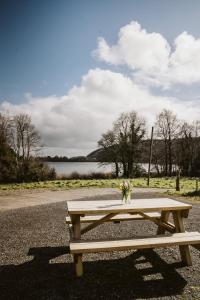 a wooden picnic table with a vase of flowers on it at Innish Beg Cottages in Blaney