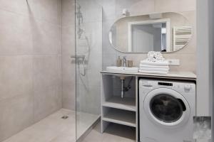 ein Badezimmer mit einer Waschmaschine und einem Spiegel in der Unterkunft COME2rest - Smilga in Juodkrantė