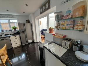a kitchen with a refrigerator and a counter top at The Homestay Get Away in Kent
