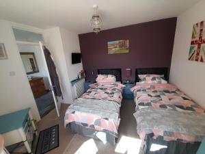 a bedroom with two beds and a wall at The Homestay Get Away in Kent