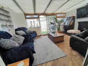 a living room with couches and a flat screen tv at The Homestay Get Away in Kent