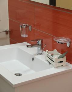 a bathroom sink with a faucet on top of it at Appartamento Alla Marmora Porto Empedocle in Porto Empedocle
