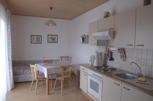 a kitchen with a table and a table and chairs at Landhaus Zechner in Schiefling am See