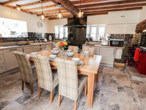 a kitchen with a wooden table and chairs at Nant Y Celyn in Ruthin