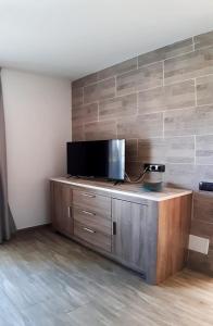 TV a schermo piatto in cima a un armadio in legno di Casa Filo, maravilloso apartamento en Morro Jable a Morro del Jable