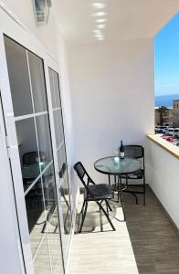 a table and chairs in a room with a balcony at Casa Filo, maravilloso apartamento en Morro Jable in Morro del Jable