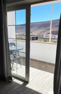 a balcony with a table and a view of the desert at Casa Filo, maravilloso apartamento en Morro Jable in Morro del Jable