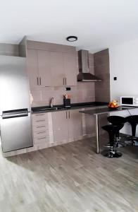 a kitchen with stainless steel appliances and a table at Casa Filo, maravilloso apartamento en Morro Jable in Morro del Jable