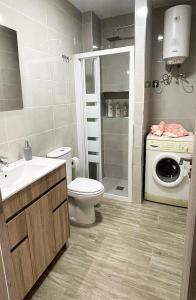 ein Badezimmer mit einem WC und einer Waschmaschine in der Unterkunft Casa Filo, maravilloso apartamento en Morro Jable in Morro del Jable