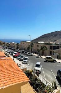 um parque de estacionamento com carros estacionados em frente a um edifício em Casa Filo, maravilloso apartamento en Morro Jable em Morro del Jable