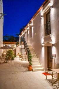 un edificio con escaleras, mesas y sillas en un patio en Philikon Luxury Suites en Rethymno Town