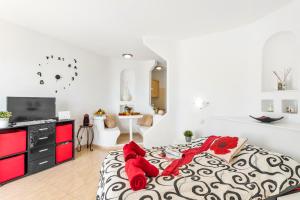 a bedroom with a large bed with red accents at 1316 Ocean View Studio Paraiso in Playa Paraiso