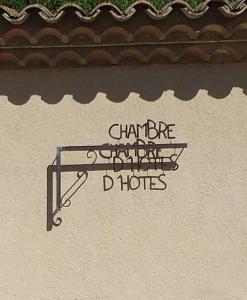 een bordje aan de zijkant van een gebouw dat zich aanpast aan de ongelukkige conflictvloeren bij Les Chêneslierres in Lourmarin