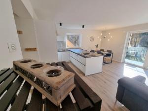uma sala de estar com uma mesa de madeira e uma cozinha em Maison Vert - Neuwertige Wohnung mit Terrasse em Collalbo