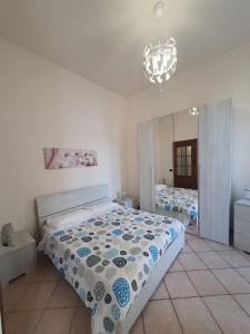 a bedroom with a large bed and a chandelier at Mini Suite Trevigi in Casale Monferrato