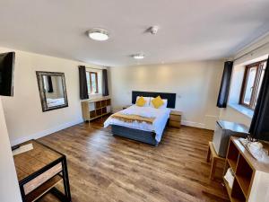 1 dormitorio con 1 cama y suelo de madera en Lillypool Farm, en Shipham