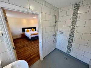 a bathroom with a shower and a bed in it at Lillypool Farm in Shipham