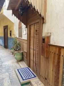 - une entrée pour un bâtiment avec une porte en bois dans l'établissement Dar Zin, à Fès