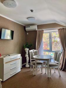ein Esszimmer mit einem Tisch, Stühlen und einem Fenster in der Unterkunft Hotel Korona in Kropywnyzkyj