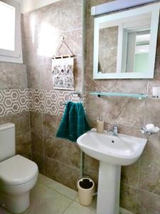 een badkamer met een wastafel, een toilet en een spiegel bij Relax studio, "Park Residence" in Trikomo
