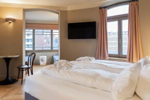 a bedroom with a large white bed and a window at Mimosa Suites in Westerland +26 photos