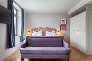 a bedroom with a purple couch in front of a bed at Mimosa Suites in Westerland