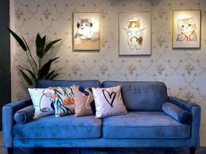 ein blaues Sofa mit Kissen im Wohnzimmer in der Unterkunft Tropicana 218 Macalister Sea & City View by stayCATion Homestay in George Town