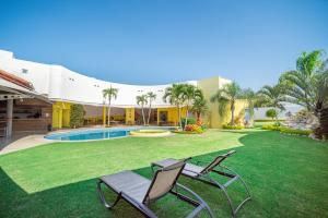 a yard with two lawn chairs and a pool at Hotel Magico Inn in Cuautla Morelos