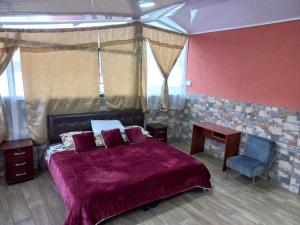 een slaapkamer met een paars bed en een blauwe stoel bij Hostal La Casa De Rodrigo in Baeza