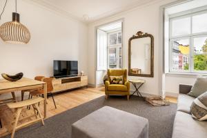 a living room with a couch and a table and a mirror at Beautiful Apartment close to Praça do Comércio by LovelyStay in Lisbon