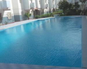 a large blue swimming pool in front of a building at Suit Home in Martil +8 photos