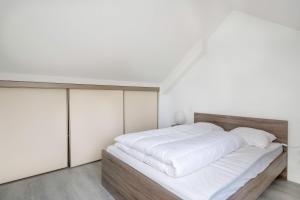 a bedroom with a large bed with white sheets at Vacances au plus proche de la Petite Mer in Arzon