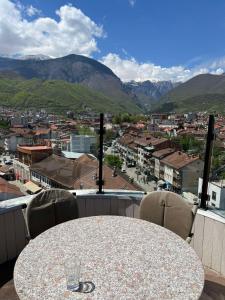 a table with chairs and a view of a city at Apartment Alpi in Peje