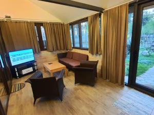a living room with a couch and a television at House & Yard Sesil XL 90m to beach in Ureki