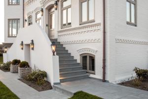a white house with a staircase in front of it at Mimosa Suites in Westerland